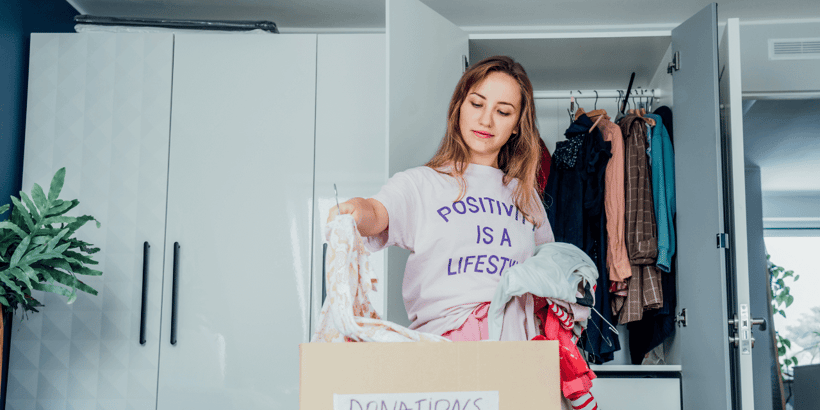 A person sorting through clutter in a room, representing the discovery and journey of decluttering